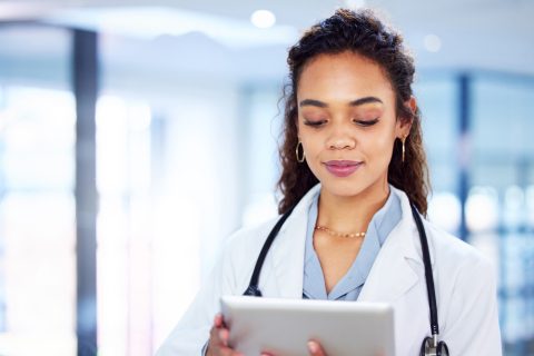Professional, woman and doctor with tablet in hospital for research, information and patient results as specialist. Female person, technology and surgeon for diagnosis or treatment with Telehealth.